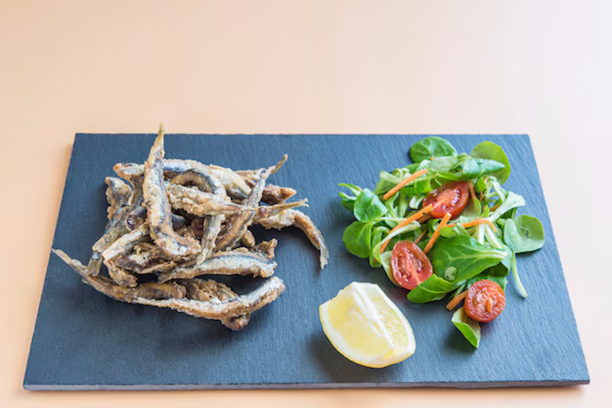 Amigos compartiendo tapas de pescado Tarragona en terraza